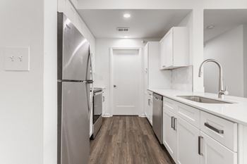 a row of urinals in a bathroom with white walls and wood floors at Polo Run Apartments, Indiana